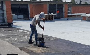 Persona de PIVISA realizando un mantenimiento industrial de impermeabilización en naves industriales