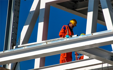 Ingeniero supervisando la construcción de una estructura metálica para naves industriales