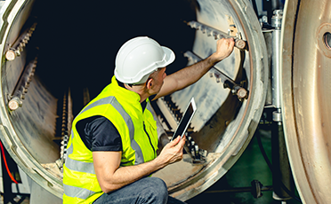 Ingeniero realizando mantenimiento industrial en una estructura metálica para naves industriales