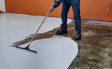 Persona realizando mantenimiento a piso epóxico, mantenimiento industrial